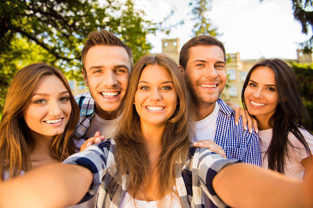 Group of young adults smiling taking selfie